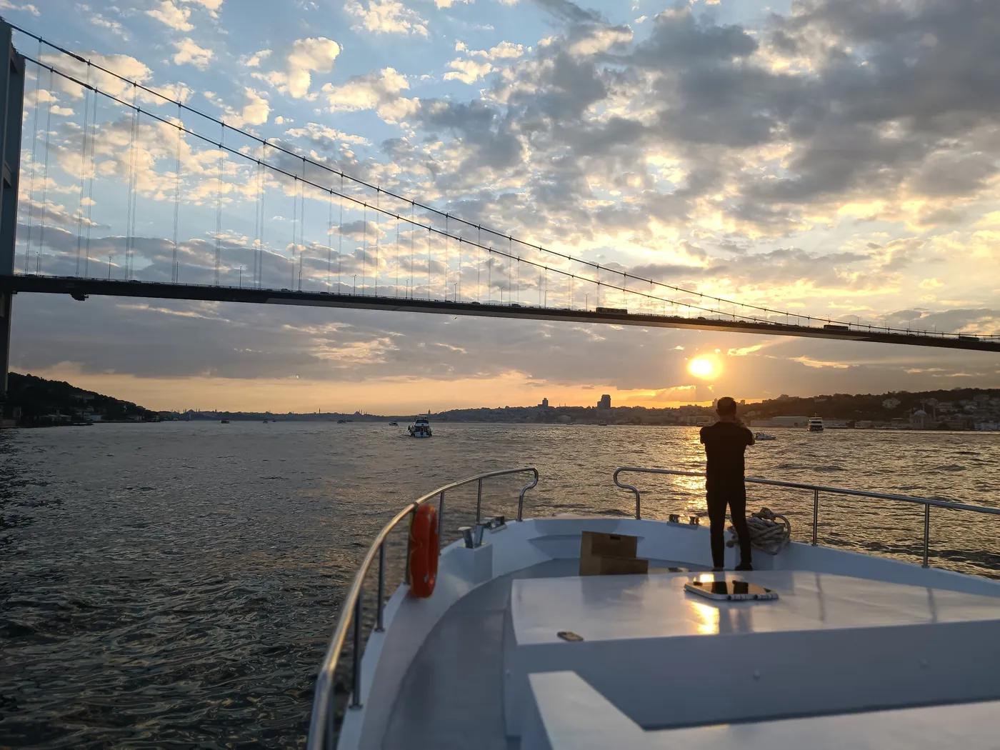 Private yacht at sunset under the Bosphorus Bridge