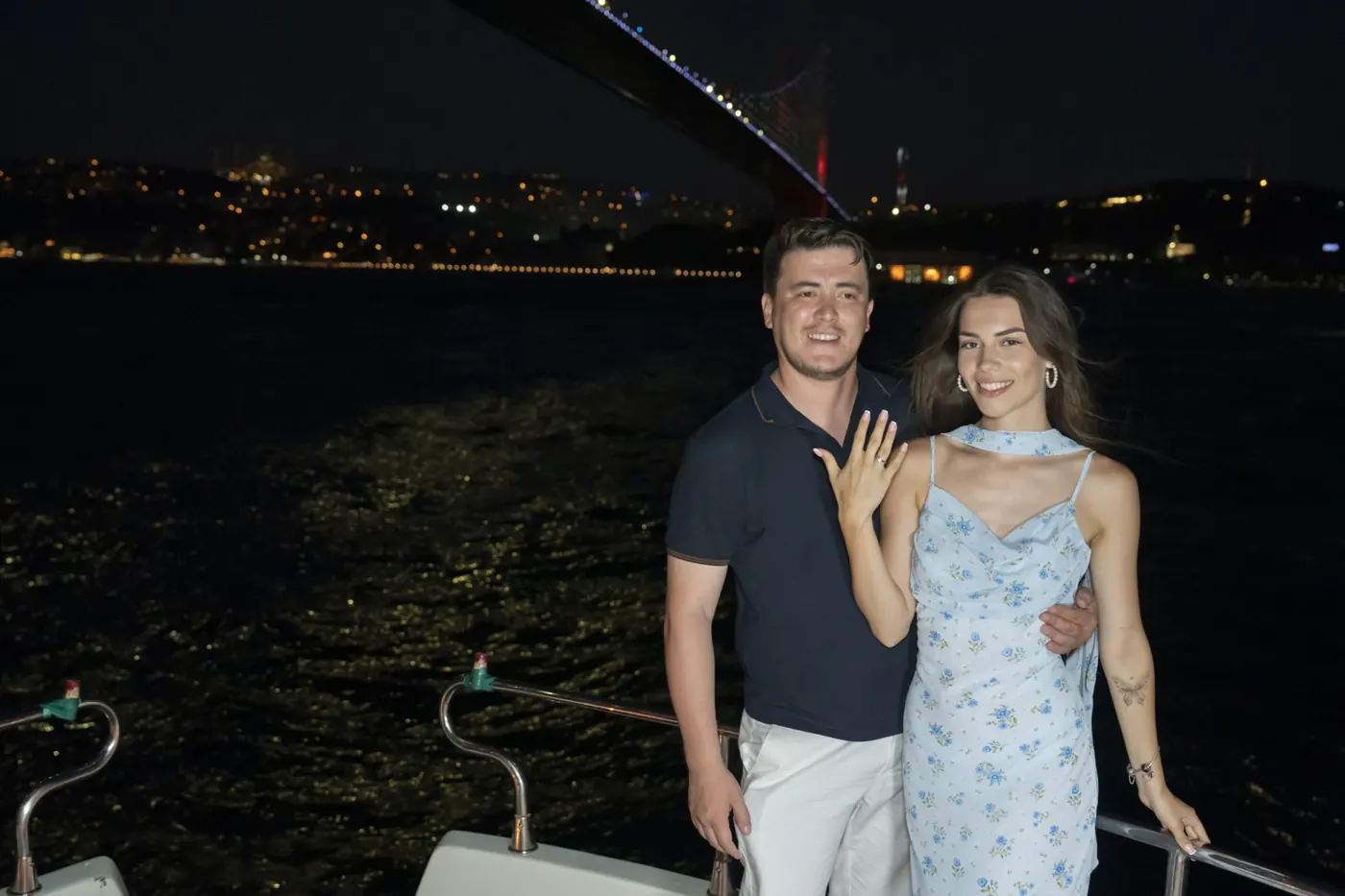Couple after a yacht proposal under the Bosphorus Bridge