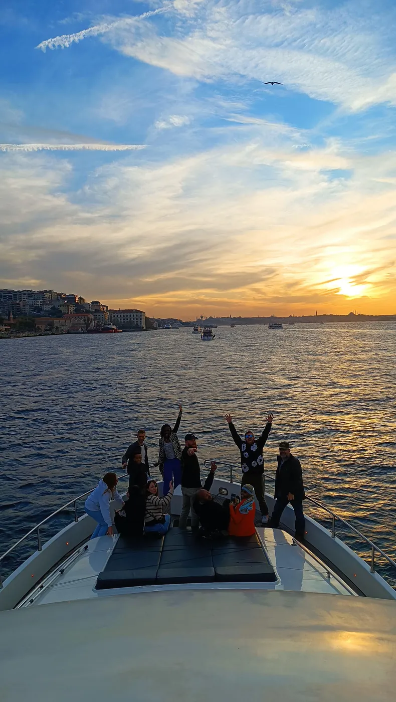 Guests celebrating on the yacht bow at sunset